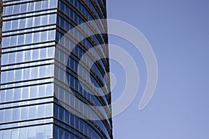 Side view of a striped blue glass window wall of a corporate building.