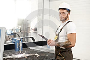 Side view of strong mechanic in protective glassesn working