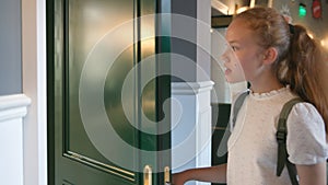 Side view of teen girl being late for class knock at classroom door and enter