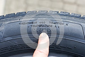 Side view of tire with tire traction rating, treadwear index and tire outside designation photo