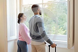 Side View Of Tourists Couple Near Window In Hotel Interior