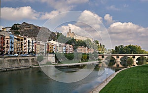 Side view of a town with its river and a church on a hill