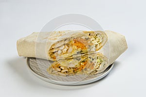 Side view of Two parts of shawarma roll on plate, isolated on background. Turkish donner street food wrapped in lavash bread