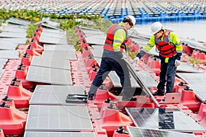 Side view of two professional technician workers hold solar cell panels with check problem during installation or set up to the