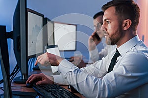 Side view. Two stock traders working in the office with exchange technology