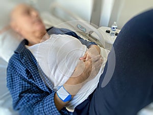 Side view of unrecognizable senior man relaxing in hospital ward