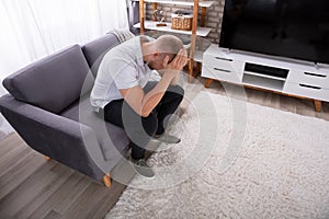 Upset Man Sitting On Sofa