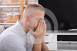 Upset Man Sitting On Sofa