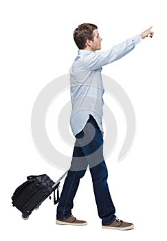 Side view of walking business man with suitcase talking on the phone