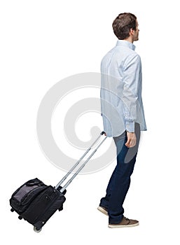 Side view of walking business man with suitcase talking on the phone