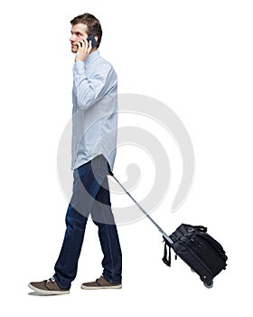 Side view of walking business man with suitcase talking on the phone