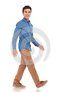 Side view of a walking smiling casual man