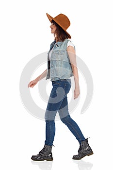 Side View of Walking Smiling Young Woman In Brown Suede Hat