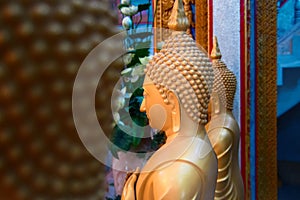 Side view wax statues of Buddhist monks in the temple. Big golden figures. Copy space.