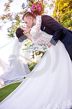 Side view of wedding couple kissing at lawn