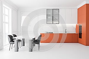 Side view of white and orange kitchen with table