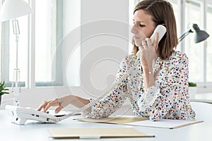 Side view of a woman dialing telephone number