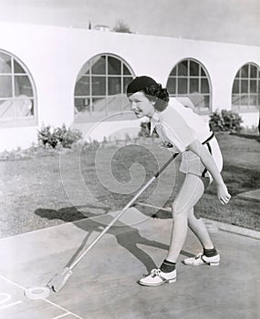 Side view of woman playing shuffleboard