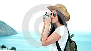 Side view woman professional photographer taking photo using vintage film camera on waterfront