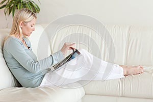 Side view of woman reading on her couch