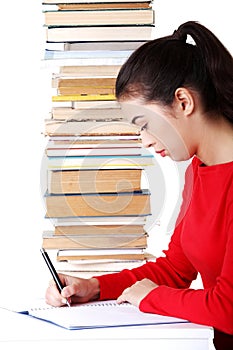Side view woman sitting with stack of books