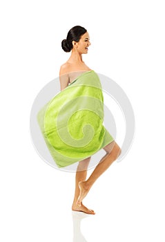 Side view woman standing wrapped in towel