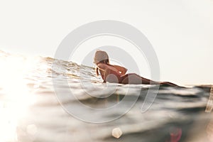 side view of woman in swimming suit surfing