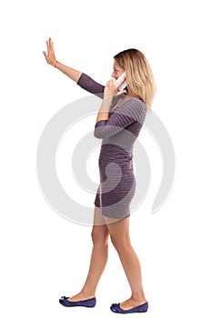 Side view of a woman walking with mobile phone.