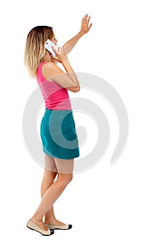 Side view of a woman walking with a mobile phone