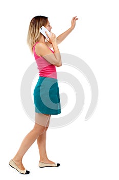 Side view of a woman walking with a mobile phone