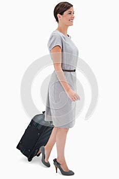 Side view of woman with wheely bag