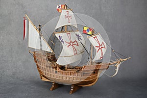 Side view of a wooden model of a three-masted sailing ship lying on wooden stands photo