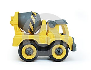 Side view of Yellow plastic concrete cement mixer truck toy isolated on white background.