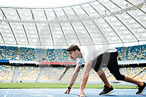 Side view of a young athlete at starting position