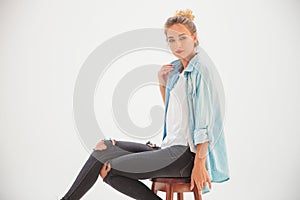 Side view of a young blonde casual woman sitting