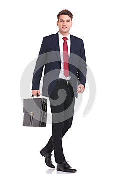 Side view of a young business man holding a brief case