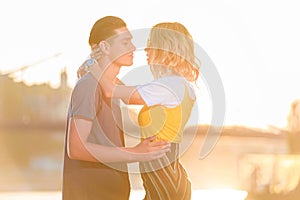 side view of young couple going to kiss on river beach