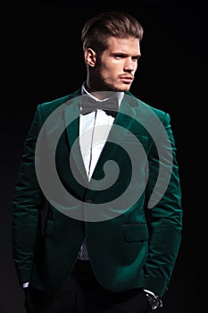 Side view of a young elegant man in green velvet suit