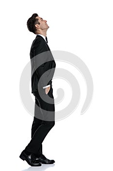 Side view of young elegant model walking and looking up