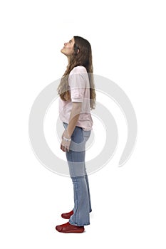 side view of a young girl standing and looking up on white