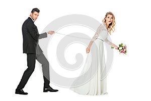 side view of young groom with chain and leashed shocked bride