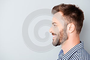 Side view of young happy smiling bearded man