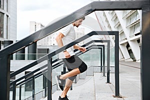 Side view of a young male runner running upstairs