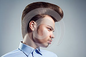 Side view of young man with retro classic pompadour hairstyle. photo