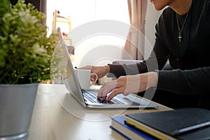 Young man sitting in living room and using computer laptop.