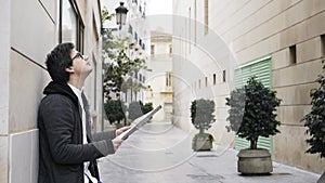 Side view of a young man studying a map in a Valencia street