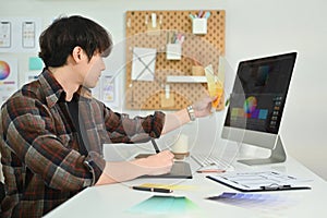 Side view of young man UX graphic designer working together for mobile application software design project at