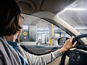 Side view of young single woman looking waiting for the ticket at the parking