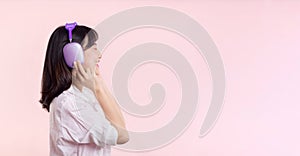 Side view young smiling cheerful fun woman she wear pink shirt white t-shirt headphones listen to music use mobile cell phone