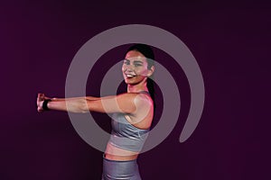 Side view of young smiling female stretching and flexing her hands